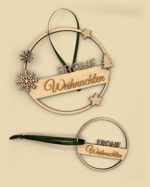 Kranz aus Holz mit Schneeflocken, Sternen, Tannenbaum und dem Schriftzug Frohe Weihnachten, dazu ein kleiner Anhänger mit grüner Schleife