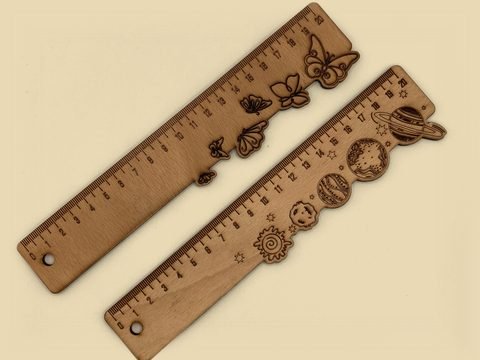 Zwei Holzlineale mit Schmetterlingen und Planeten am Rand